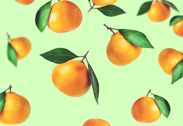 不同形状的橘子与树叶在彩色背景上隔离。橘子在空中飞舞。圣诞合成的橘子和叶子。图片下载