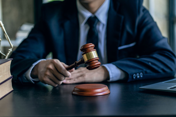 律师办公室的法律顾问与法官的柱和正义女神的天平在桌上与高卡迈书和合同文件。图片下载