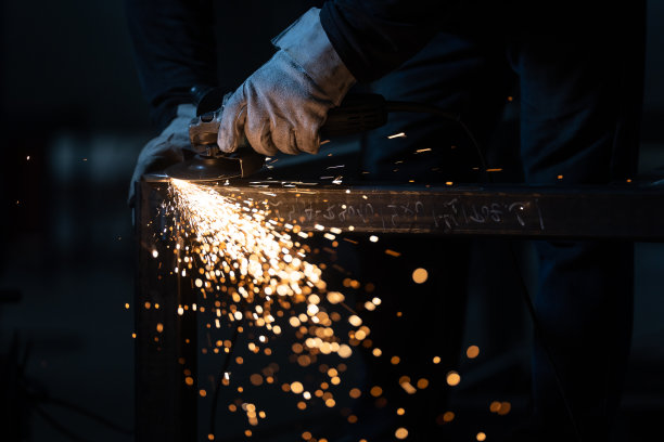 用研磨机在铁上工作的人。图片下载