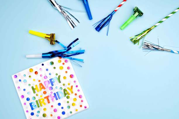 生日晚会的背景。邀请函，派对用品，生日哨子，派对眼镜和帽子，礼品盒，旗帜和餐巾。图片下载