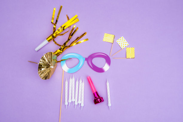 生日晚会的背景。邀请函，派对用品，生日哨子，派对眼镜和帽子，礼品盒，旗帜和餐巾。图片下载