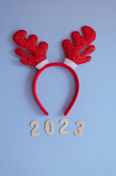 数字2023的俯视图。红色卡通鹿角特写。蓝色背景。新年，庆祝圣诞图片下载