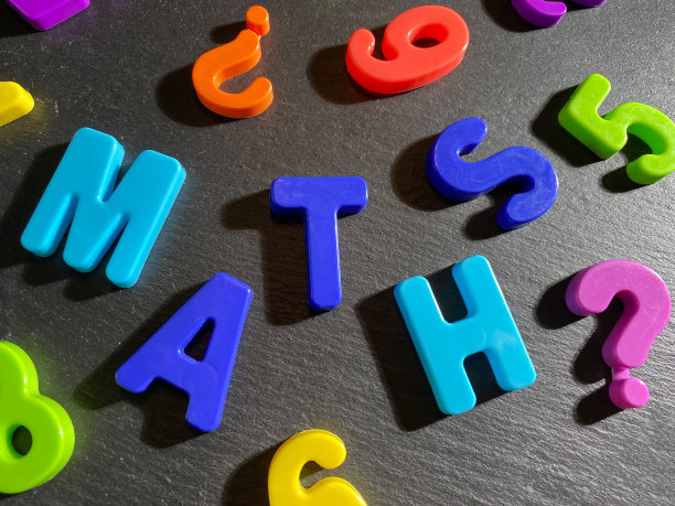 成堆的彩色数字在黑色的石头背景。刻字数学。概念:回到学校，数学。前视图。有选择性的重点图片下载