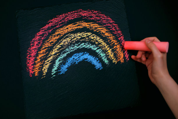 这个孩子在一块粗糙的黑板上画了一道彩虹图片下载