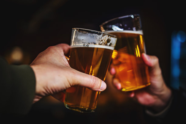 两个朋友在酒吧里手拿精酿啤酒敬酒。酒吧图片下载