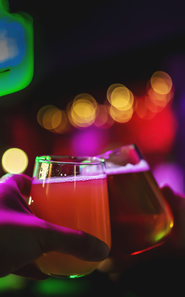 两个朋友在酒吧里手拿精酿啤酒敬酒。酒吧图片下载