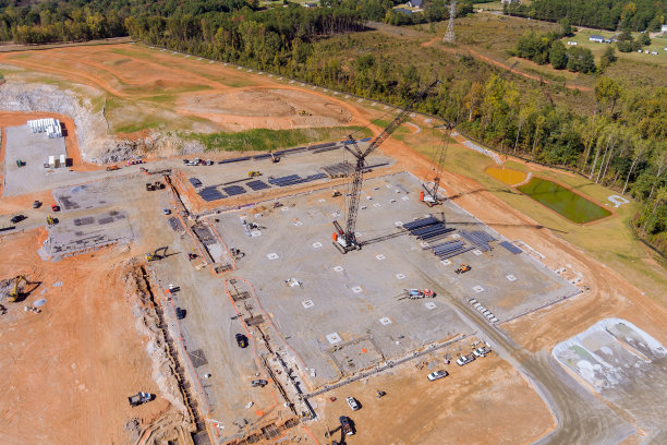 在这张建筑工地的全景图中，你可以看到在一幢高层建筑上工作的大型起重机图片下载