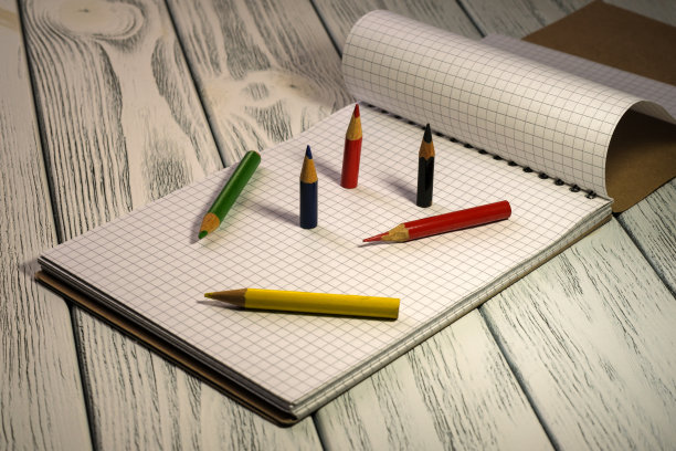 打开的空白笔记本，带有撕下的方格叶子图片下载