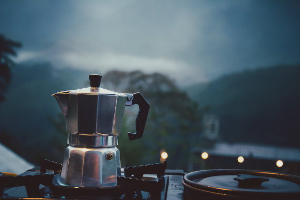 户外厨房设备营火和冲泡茶壶摩卡咖啡滴杯，木桌野营煤气炉设置在自然户外，山地背景，概念野营和旅行，复古色调图片下载