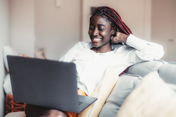 黑人女孩在室内使用笔记本电脑图片下载