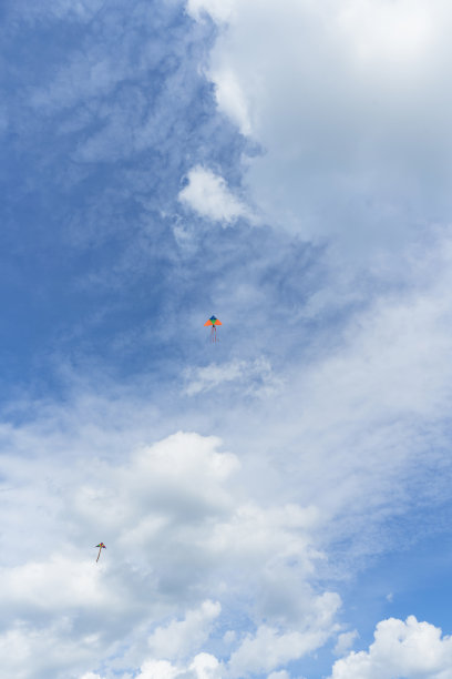 两只风筝在蓬松的白云中高高飞翔图片下载