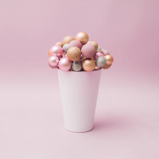 新年和圣诞节用花的形式装饰。粉色粉彩背景上的白色花瓶。图片下载