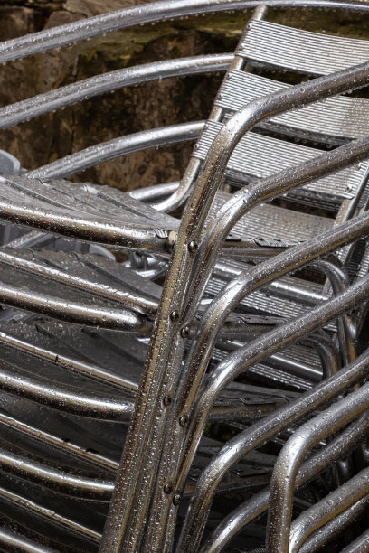 椅子折叠。咖啡馆前的不锈钢抛光桌子被雨水和露水打湿了。户外露台的季节结束了图片下载