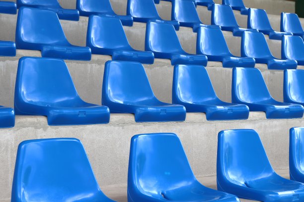 蓝色塑料扶手椅排成一排。图片下载