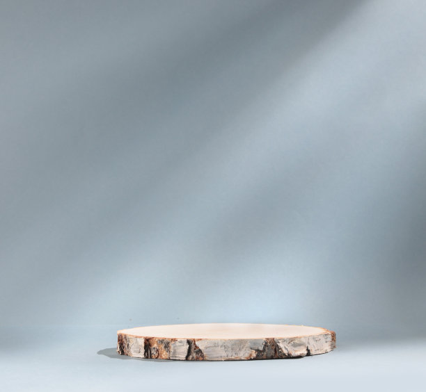 圆形木板圆柱形桦木板在灰色背景与阳光平台。展示产品的空陈列柜。高质量的照片图片下载