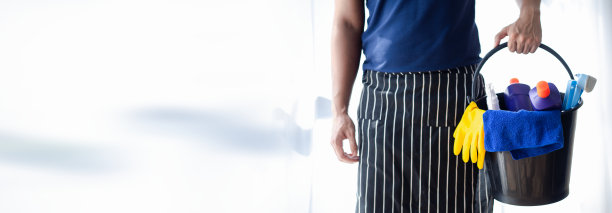打扫房间的人，清洁人员站着拿着一桶清洁设备。清洁人员。保持组织内的清洁。图片下载