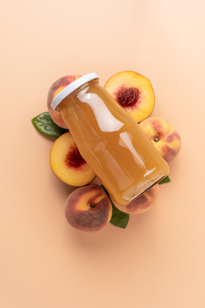 水蜜桃汁的玻璃瓶躺在整齐排列的桃子米色背景。图片下载