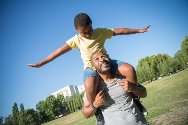 快乐的非裔美国父亲把儿子抱在脖子上图片下载