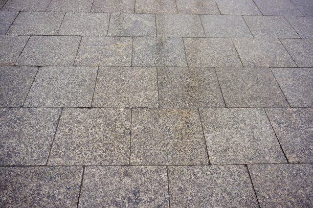 高角度特写镜头的鹅卵石地面与方形瓷砖图片下载