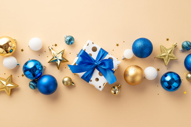 圣诞夜的概念。俯视图照片明星饰品白色蓝色金色小玩意儿礼物盒缎带蝴蝶结和彩色纸屑孤立的米色背景图片下载