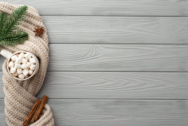 冬天的美学理念。顶视图照片杯热饮与棉花糖针织围巾松枝八角和肉桂棒在灰色的木桌背景与copyspace图片下载