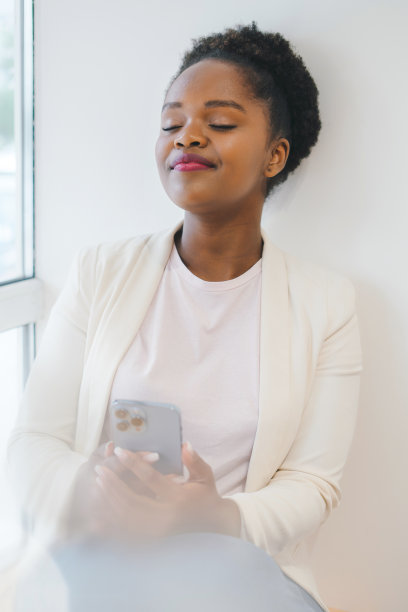 冷静，沉思非洲女商人，喝咖啡在咖啡馆用电话。人们的生活方式。图片下载