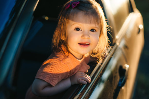 小男孩在车里望着窗外，一脸惊叹于大自然的美丽，阳光温暖着脸庞。微笑快乐的孩子。幸福的家庭,童年。儿童保健。图片下载