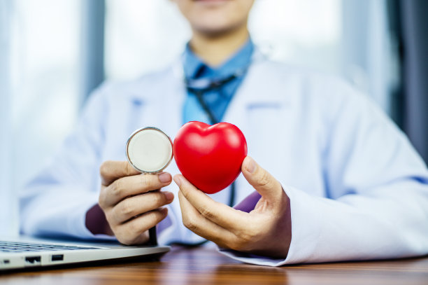医生手捧红心，保健，爱，器官捐献，正念，幸福，家庭保险和社会责任的概念，世界心脏日，世界卫生日，世界精神卫生日，祈祷的概念图片下载