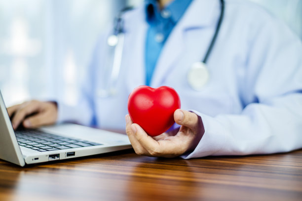医生手捧红心，保健，爱，器官捐献，正念，幸福，家庭保险和社会责任的概念，世界心脏日，世界卫生日，世界精神卫生日，祈祷的概念图片下载