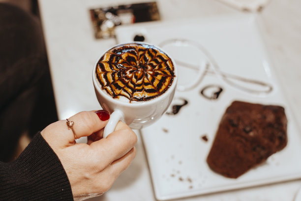 女人在咖啡馆吃咖啡和巧克力饼干，可可饼干和咖啡，甜的食物与咖啡，咖啡艺术图片下载