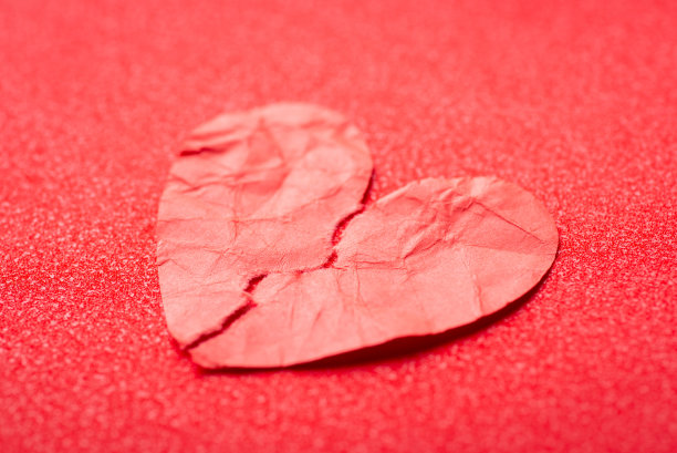 红色背景上的纸心从中间撕成两半图片下载