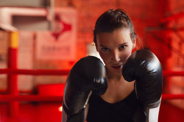 戴着拳击手套的女拳击手在体育馆训练图片下载