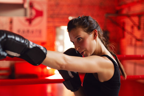 戴着拳击手套的女拳击手在体育馆训练图片下载