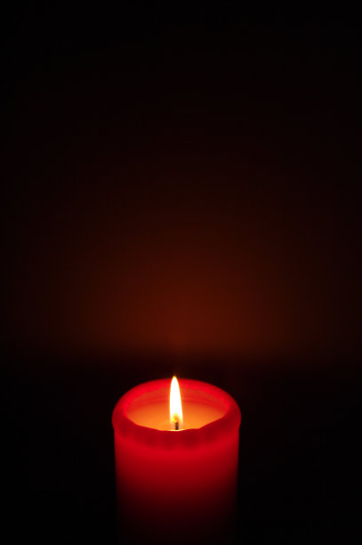 红色的蜡烛在黑暗的背景和阴影图片下载