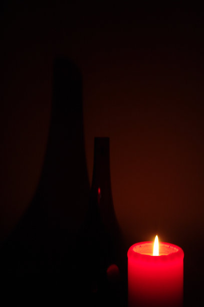红色的蜡烛在黑暗的背景和阴影图片下载