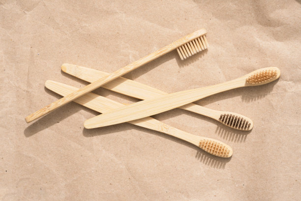许多天然木制牙刷在牛皮纸背景。天然沐浴产品和零浪费理念，有机牙膏。模型图片图片下载