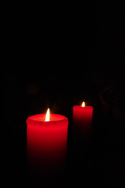 两支红色的蜡烛在黑暗的背景上图片下载