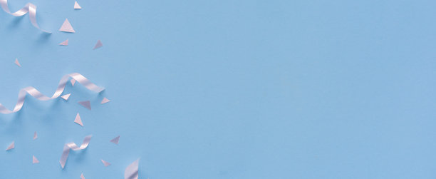 靠近一组白色的颜色滚动的丝带和纸屑在蓝绿色背景与复制空间新年快乐，嘉年华，生日和周年，概念设计图片下载