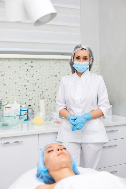 戴着蓝色面具的美容师和沙发上的女人图片下载