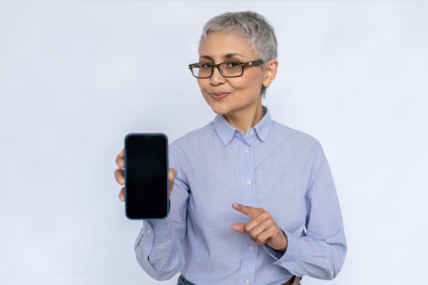 幸福的高级女商人的画像指着手机图片下载