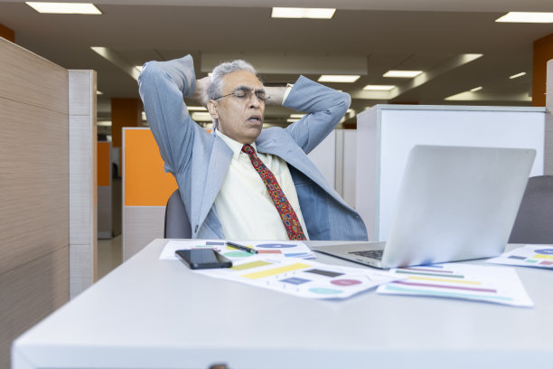 不满意的高级职员在办公室使用笔记本电脑。图片下载