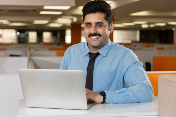 商人使用笔记本电脑，在办公室庆祝成功。图片下载