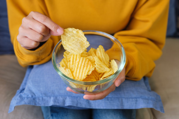 一个女人在家里摘薯片吃的特写图片图片下载