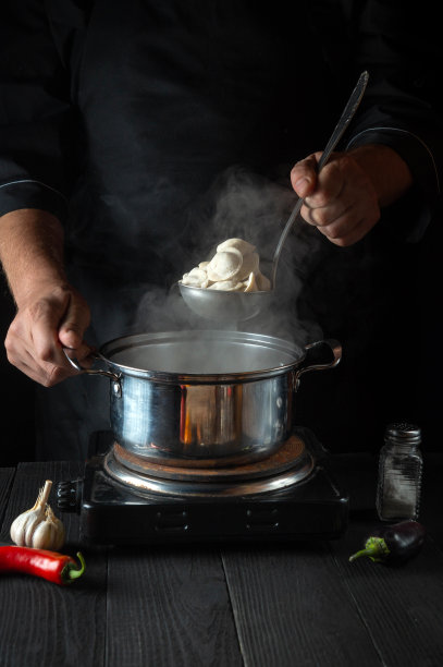 厨师在餐厅厨房用平底锅煮肉馅饺子。厨师工作时的手特写图片下载