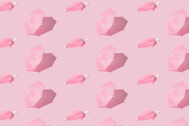 开革和封闭的粉红色伞在粉红色柔和的背景。模式。图片下载