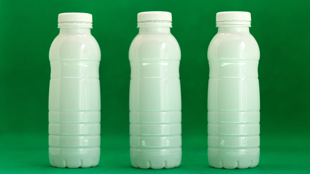 白色的瓶子在绿色的背景上排成一排图片下载