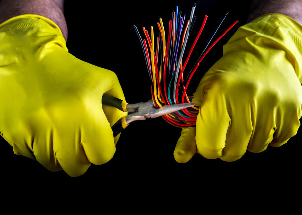 手戴电工手套，手持斜口钳，黑色背景线特写。电子产品维修的想法图片下载