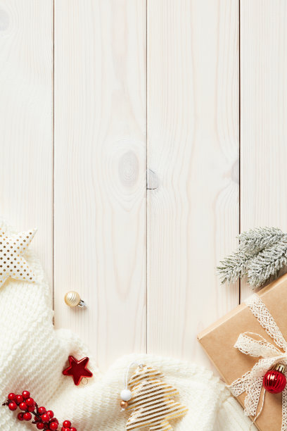 质朴的木制书桌桌上有圣诞装饰品，针织围巾，礼品盒。寒假垂直横幅模板。图片下载