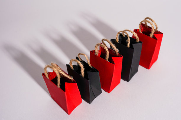 黑色星期五促销活动设计创意，红色和黑色的购物袋与灰色背景的阴影图片下载