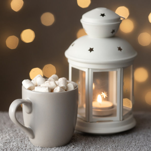 冬天假期的舒适夜晚在家里的正方形照片，有蜡烛和一杯咖啡与棉花糖图片下载
